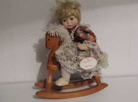 Porcelain doll on rocking clearance horse