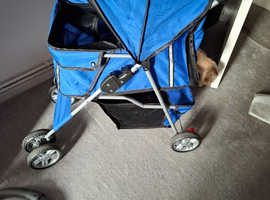 Dog pram blue good condition with rain cover and basket under neath