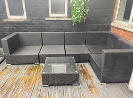 Offers large rattan corner sofa with glass table