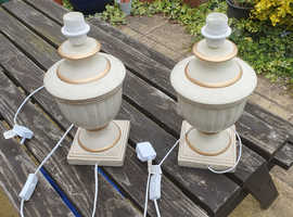 A pair of cream/gold ceramic lamps.
