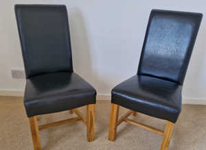 Pair of solid oak black leather high scroll back dining chairs