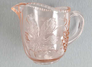 A Small Vintage Glass Jug with Orange Hues.  3.1/2" Tall.