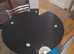 Black glass circular dining table. No chairs.