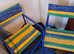 Two coloured foldaway garden chairs .